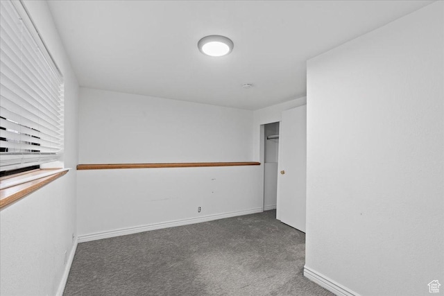 unfurnished room with baseboards and carpet