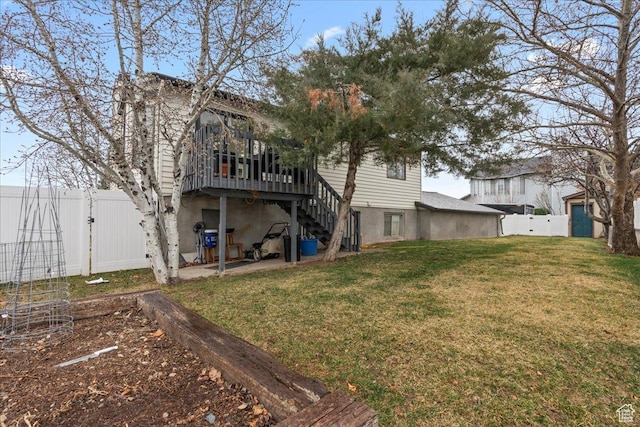 rear view of property with stairway, a gate, a fenced backyard, a deck, and a lawn