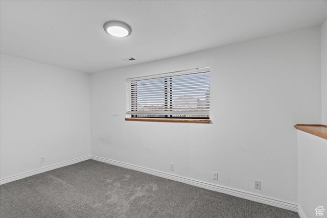 unfurnished room with visible vents, baseboards, and carpet floors