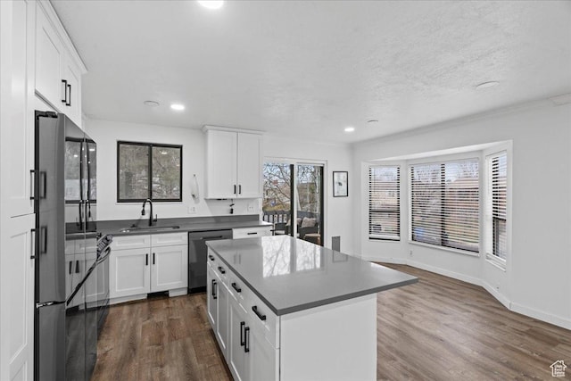 kitchen featuring dark countertops, stainless steel appliances, dark wood-type flooring, and a sink