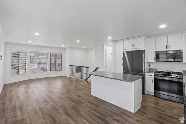 kitchen with a kitchen island, recessed lighting, stainless steel appliances, white cabinets, and dark wood-style flooring