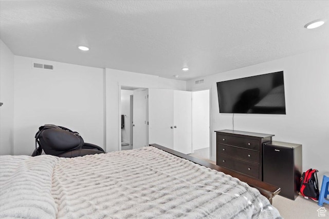 carpeted bedroom featuring recessed lighting, visible vents, and a textured ceiling