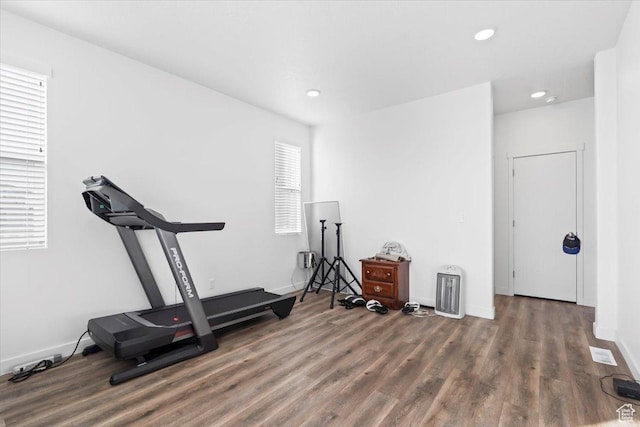 workout room with recessed lighting, baseboards, and wood finished floors