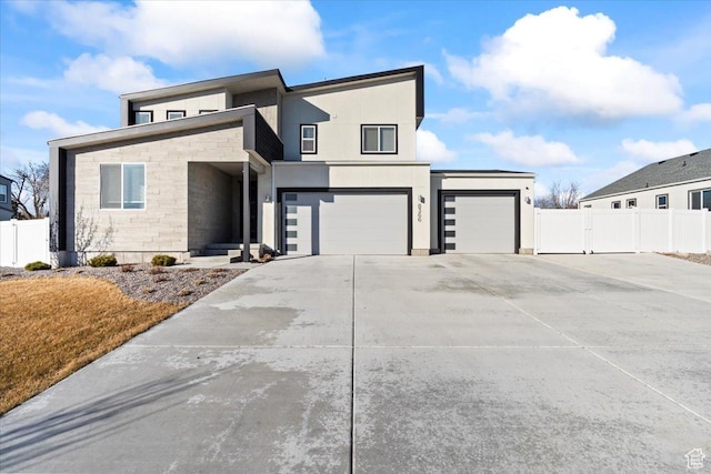 view of front of property with fence, driveway, an attached garage, stucco siding, and stone siding