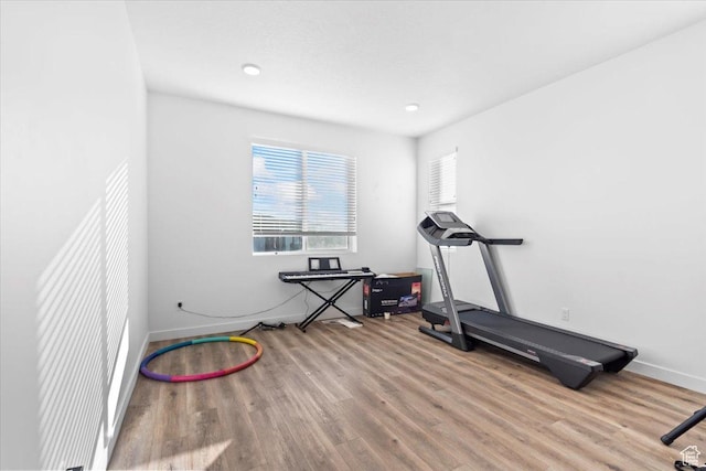 exercise area with wood finished floors and baseboards