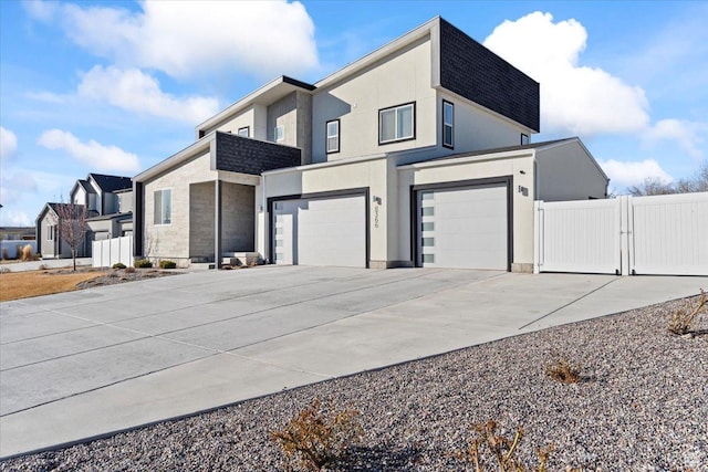 view of property exterior with fence, an attached garage, driveway, and a gate