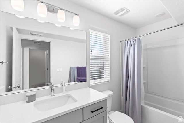 full bath with visible vents, toilet, vanity, and shower / bath combination with curtain
