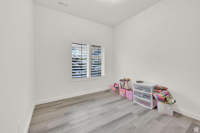 rec room featuring wood finished floors, visible vents, and baseboards