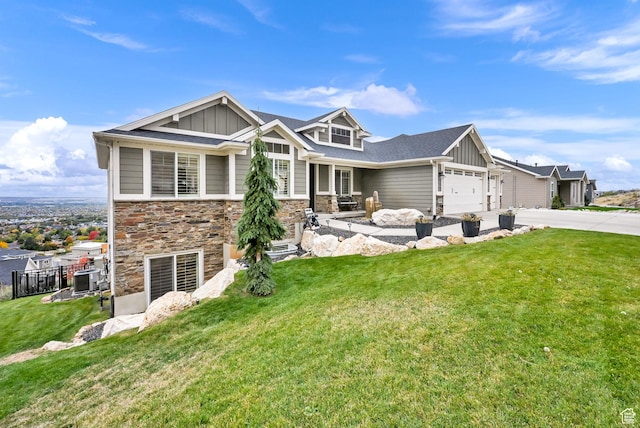 view of front of home with board and batten siding, a front lawn, driveway, stone siding, and an attached garage