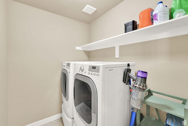 clothes washing area with washer and dryer, laundry area, baseboards, and tile patterned floors
