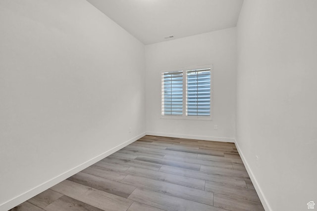 unfurnished room with visible vents, baseboards, and wood finished floors