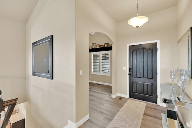 entrance foyer with baseboards and wood finished floors