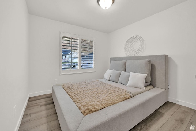 bedroom with baseboards and wood finished floors