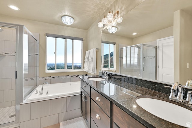 bathroom featuring double vanity, a stall shower, a garden tub, and a sink