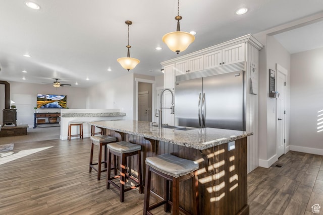 2409 W Rim Rock Dr, Stockton, UT 84071 - kitchen with dark wood-style flooring, recessed lighting, a sink, and built in fridge