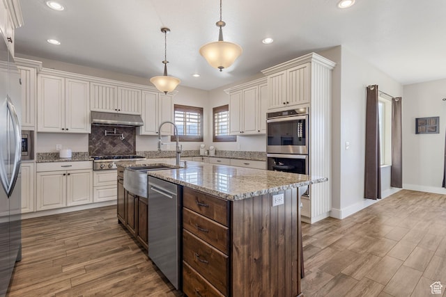2409 W Rim Rock Dr, Stockton, UT 84071 - kitchen featuring recessed lighting, appliances with stainless steel finishes, wood finished floors, hanging light fixtures, and a sink