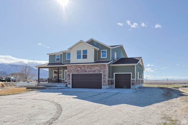 view of front of property with stone siding, a garage, and driveway