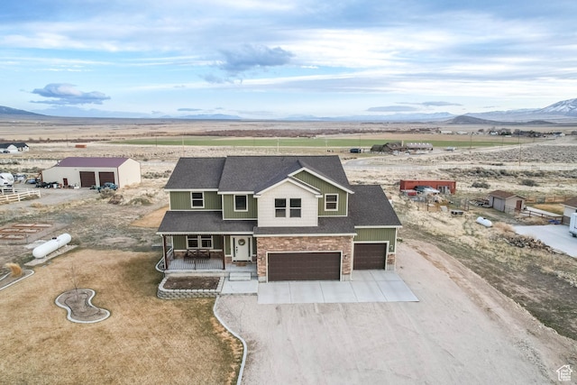 2409 W Rim Rock Dr, Stockton, UT 84071 - view of front of house featuring a mountain view, covered porch, concrete driveway, an attached garage, and a shingled roof