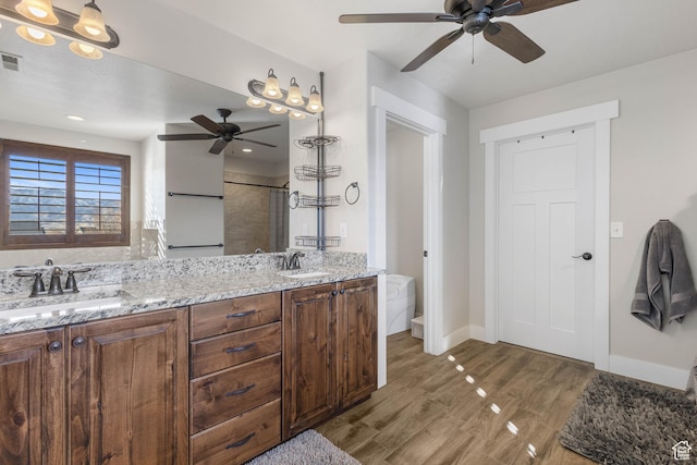 2409 W Rim Rock Dr, Stockton, UT 84071 - bathroom with double vanity, a stall shower, wood finished floors, and a sink