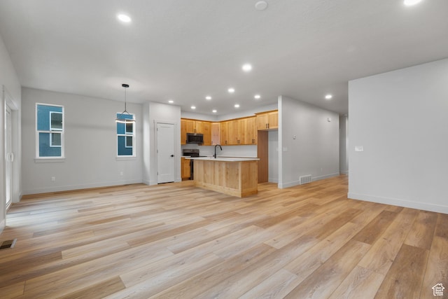6317 W Cape Ridge Ln, West Valley City, UT 84128 - kitchen with open floor plan, recessed lighting, light wood-style floors, appliances with stainless steel finishes, and light countertops