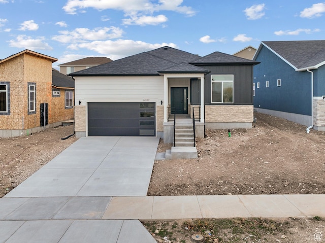 6317 W Cape Ridge Ln, West Valley City, UT 84128 - view of front of house with concrete driveway, a garage, board and batten siding, and roof with shingles
