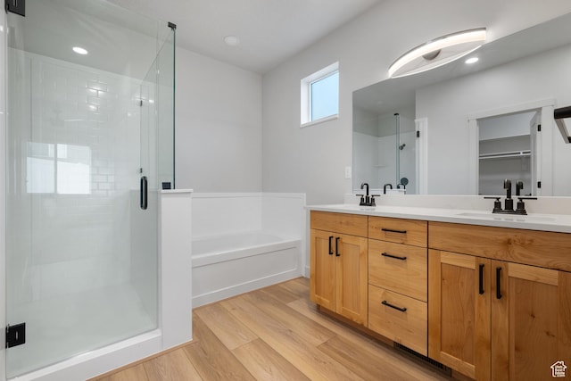 6317 W Cape Ridge Ln, West Valley City, UT 84128 - full bathroom with a stall shower, wood finished floors, a garden tub, and a sink