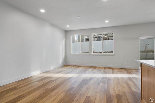 6317 W Cape Ridge Ln, West Valley City, UT 84128 - empty room with recessed lighting, baseboards, light wood-style floors, and a textured ceiling