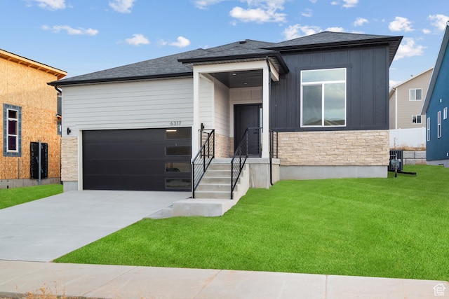 view of front facade with board and batten siding, a front yard, stone siding, and driveway