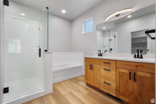 6317 W Cape Ridge Ln, West Valley City, UT 84128 - bathroom featuring a sink, a garden tub, wood finished floors, and a shower stall