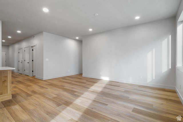 6317 W Cape Ridge Ln, West Valley City, UT 84128 - unfurnished living room with recessed lighting, baseboards, and light wood-style flooring