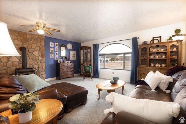 161 S Canyon Rd E, Parowan, UT 84761 - carpeted living room featuring a wood stove, a ceiling fan, baseboards, and a textured ceiling