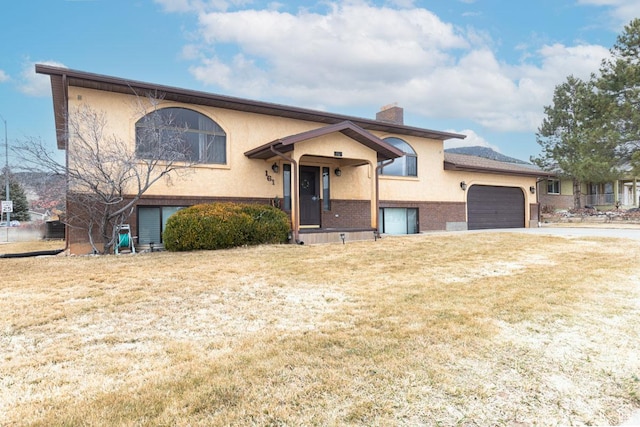 161 S Canyon Rd E, Parowan, UT 84761 - bi-level home with stucco siding, a front lawn, an attached garage, and a chimney