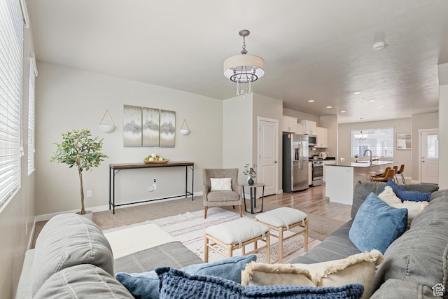 living room featuring recessed lighting, baseboards, and a notable chandelier