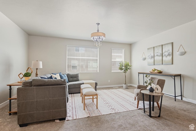 living area with baseboards, carpet, and a notable chandelier