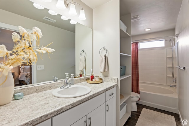 bathroom with vanity, visible vents, shower / bath combo with shower curtain, wood finished floors, and toilet