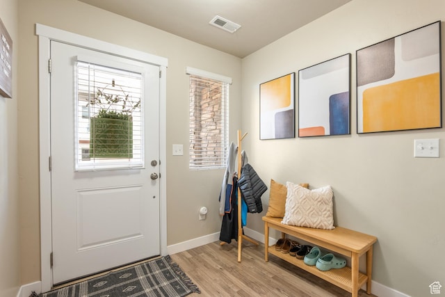 entryway with baseboards, light wood finished floors, and visible vents