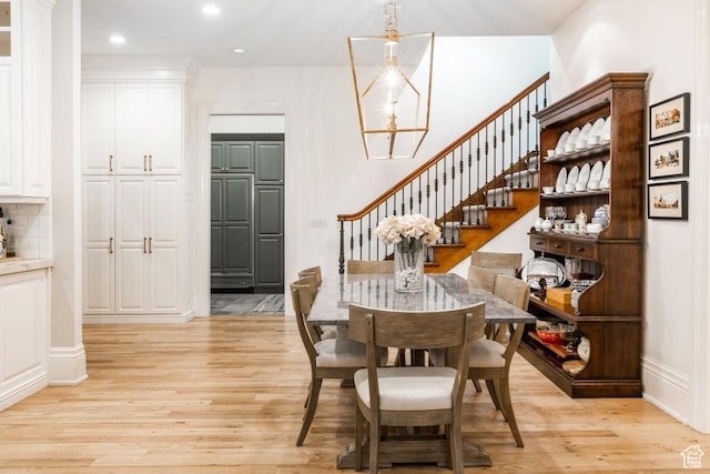 dining area with recessed lighting, light wood-style floors, a chandelier, and stairs