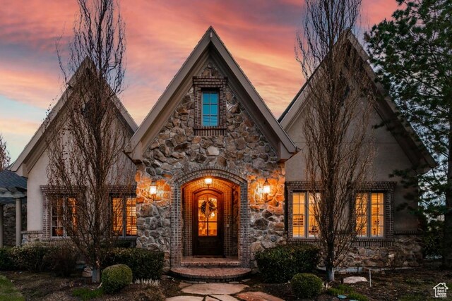 view of front facade with stone siding and stucco siding