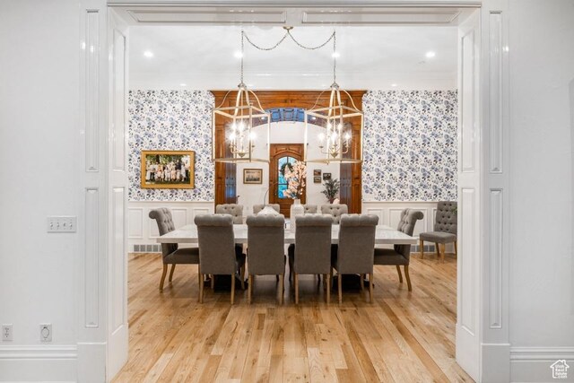 dining area featuring wallpapered walls, light wood-style flooring, a notable chandelier, and visible vents