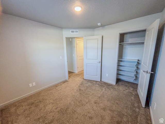 1700 S Sandhill Unit H203, Orem, UT 84058 - unfurnished bedroom with visible vents, a textured ceiling, a closet, carpet, and baseboards