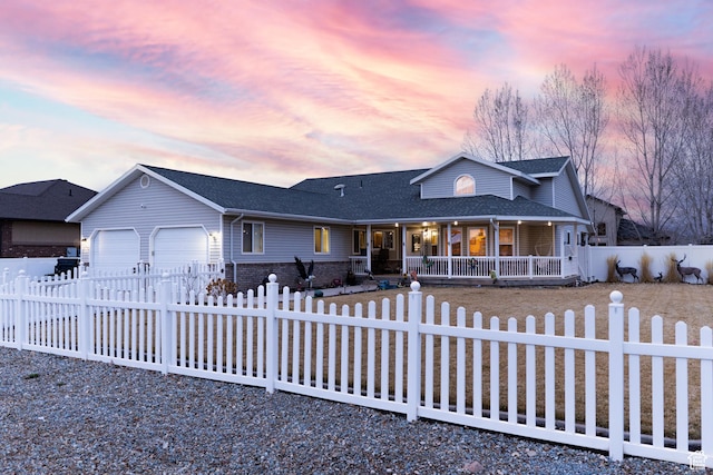ranch-style house with driveway, roof with shingles, an attached garage, covered porch, and a fenced front yard