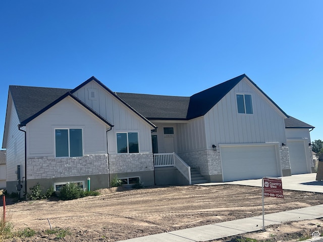 4652 W 25 N Unit 415, West Point, UT 84015 - view of front facade featuring board and batten siding, a shingled roof, concrete driveway, an attached garage, and stone siding