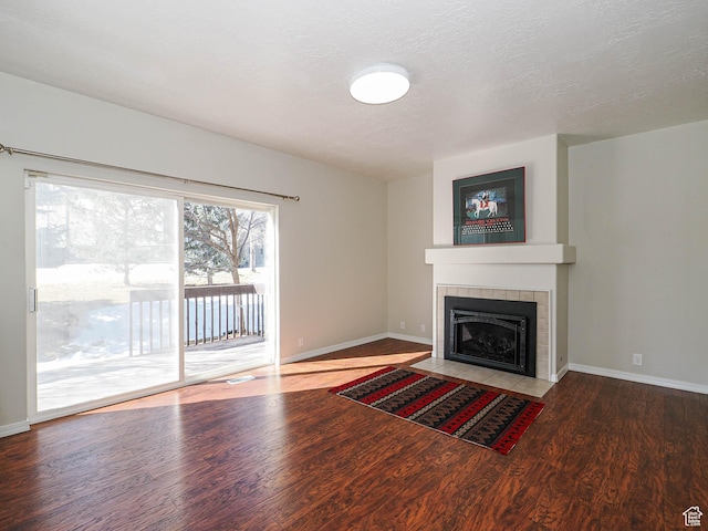 8004 Mustang Loop Rd, Park City, UT 84098 - unfurnished living room with a tiled fireplace, wood finished floors, baseboards, and a textured ceiling