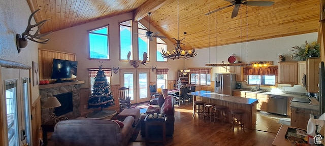 5085 Trumpeter, Island Park, ID 83429 - living room featuring beamed ceiling, ceiling fan with notable chandelier, wood finished floors, a stone fireplace, and wood ceiling