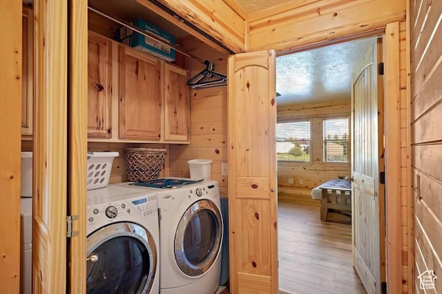 5085 Trumpeter, Island Park, ID 83429 - clothes washing area featuring light wood-style floors, cabinet space, separate washer and dryer, and wood walls