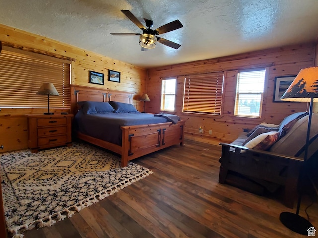 5085 Trumpeter, Island Park, ID 83429 - bedroom featuring wooden walls, multiple windows, a textured ceiling, and wood finished floors