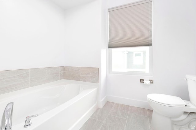 bathroom featuring baseboards, toilet, and a garden tub