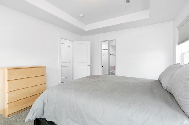 bedroom featuring visible vents, a tray ceiling, and carpet floors