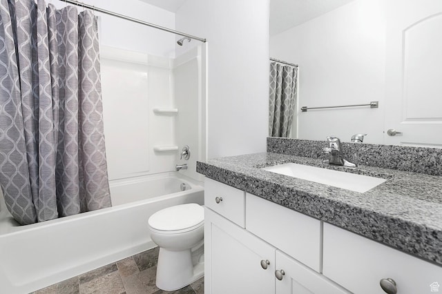 full bathroom with stone tile floors, toilet, shower / bath combo with shower curtain, and vanity