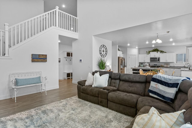 7382 W Butter Hollow Cir, Herriman, UT 84096 - living room with wood finished floors, baseboards, stairway, a chandelier, and recessed lighting